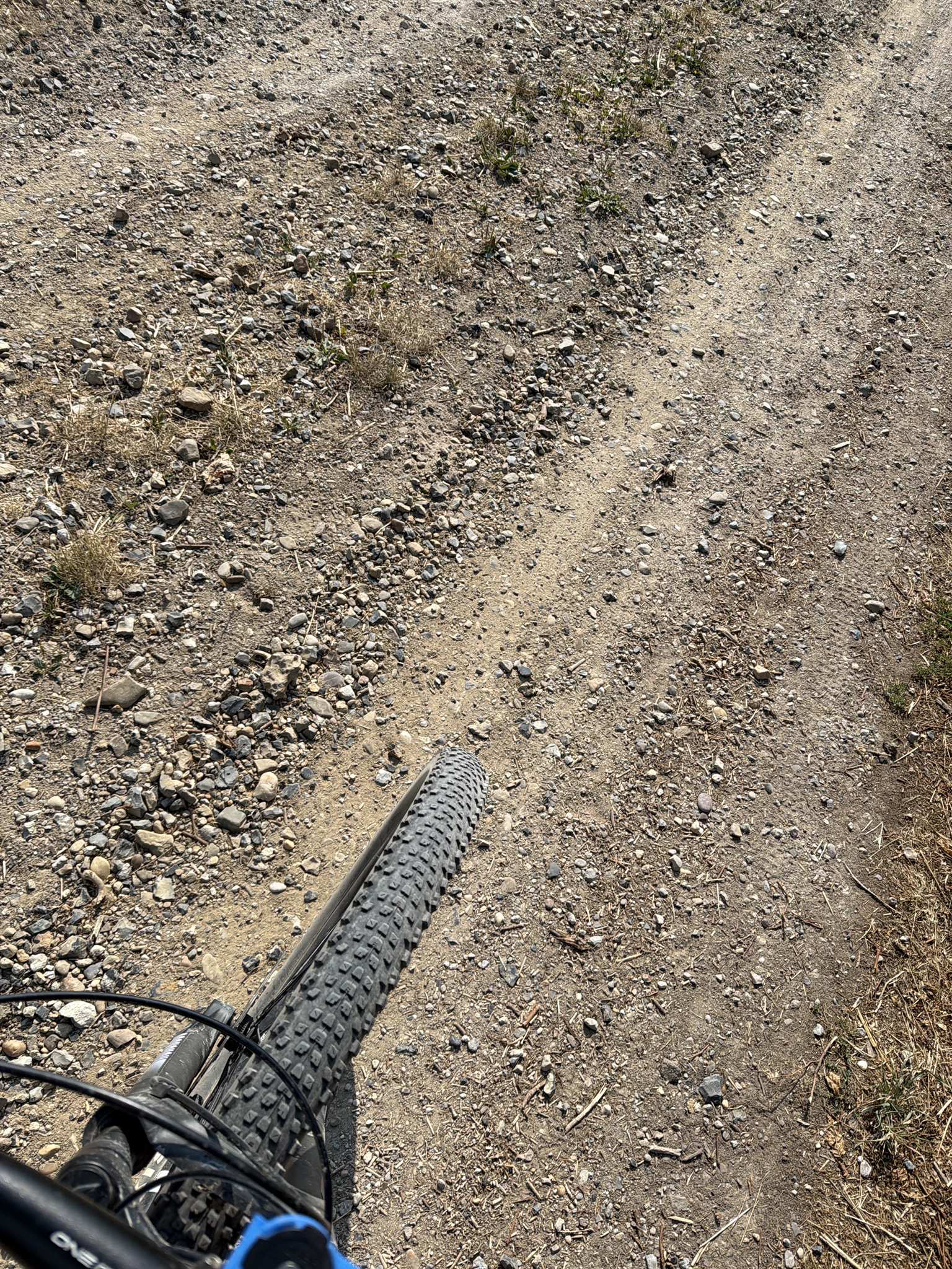 Voorwiel van een mountainbike op een pad met los grind